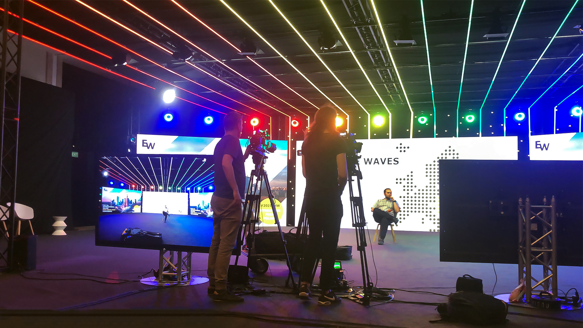 East meets West - Oprawa wizualna konferencji na żywo - zdjęcie ze studia, w tle ekrany, światła; na pierwszym planie kamery