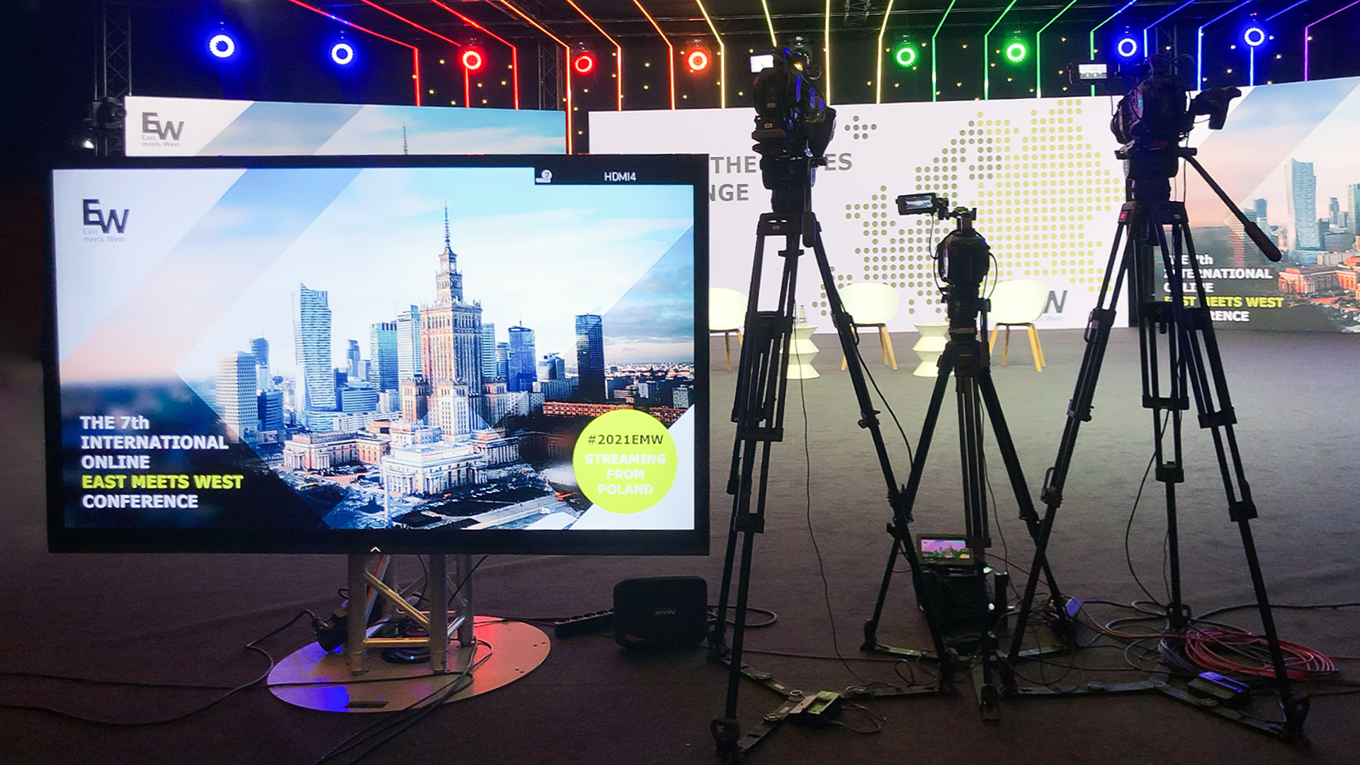 East meets West - Oprawa wizualna konferencji na żywo - zdjęcie ze studia, w tle ekrany, światła; na pierwszym planie kamery i podgląd streemu
