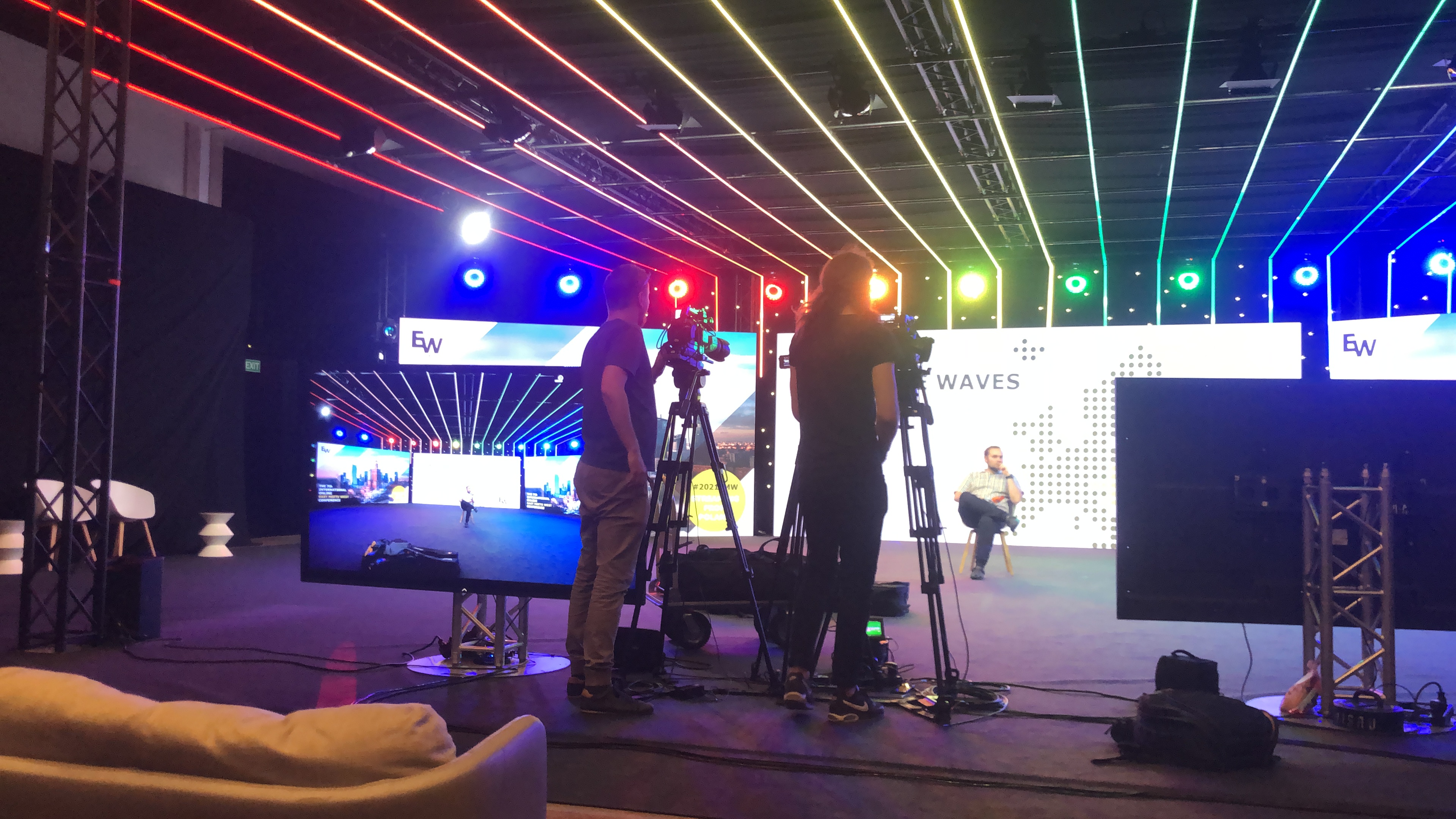 East meets West - Oprawa wizualna konferencji na żywo - zdjęcie ze studia, w tle ekrany, światła; na pierwszym planie kamery