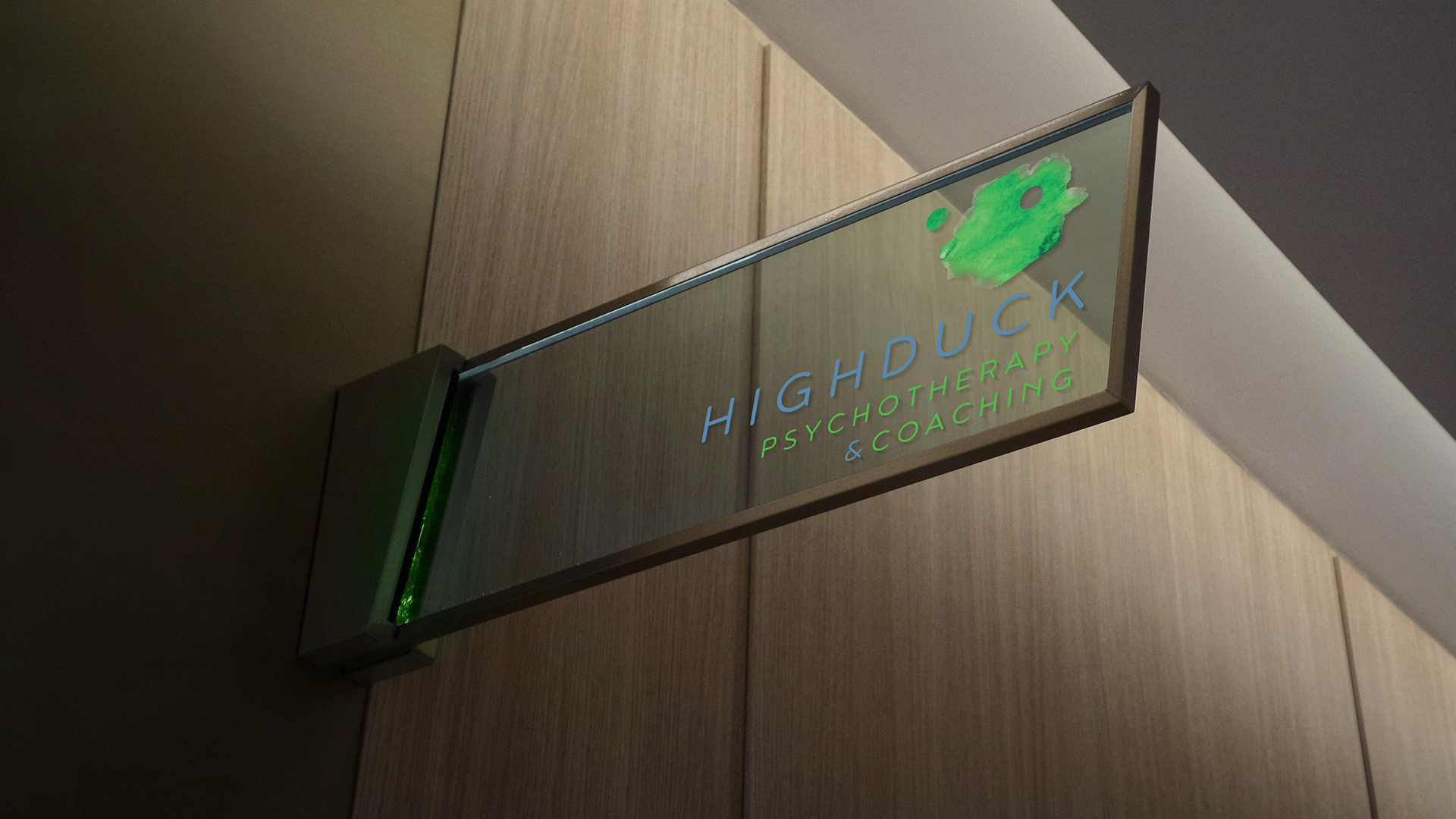 Highduck identyfikacja wizualna - szklany szyld z zielonym napisem nazwy i logo; całość na tle ściany z brązowych paneli